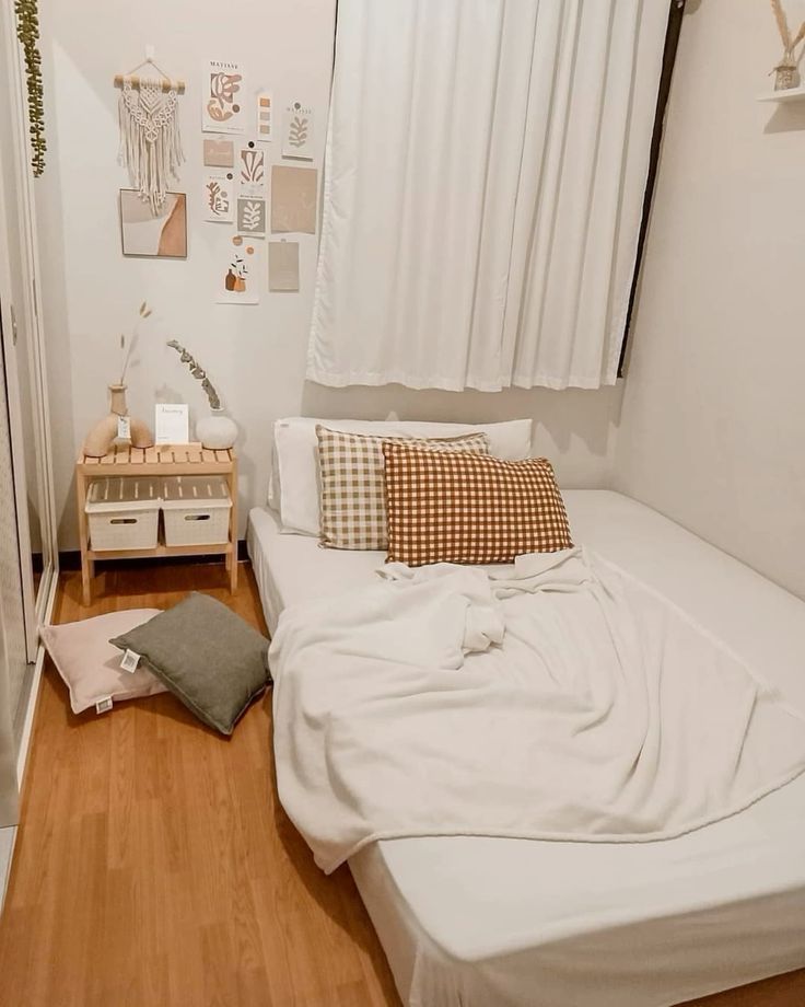 a bedroom with white walls and wood floors