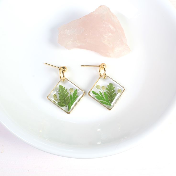 Fern leaf earrings, handmade resin jewelry. Pressed flower nature dangles in silver or gold. Real green ferns, leaves, and seeds are set in resin in these diamond-shaped, square dangles. Set on a ball stud, perfect as a nature lover gift, or for wildflower weddings. Dainty and lightweight.  Dimensions: From stud to bottom of earring - 1.25 inches Width - just over 3/4 inches Ball studs are hypoallergenic and each pair comes with a steel and silicone backing for tarnish-resistance and sensitive l Flower Resin Jewelry, Botanical Jewelry, Square Diamond, Wildflower Wedding, Geometric Jewelry, Gifts For Nature Lovers, Leaf Earrings, Pressed Flowers, Resin Jewelry