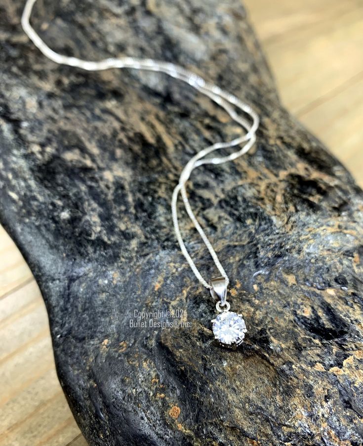 Our .925 Sterling Silver Cubic Zirconia necklace is as brilliant as the real thing!  Made with a .75 Carat brilliant cut CZ and .925 Sterling Silver components and chain.  Your choice of 16", 18", 20", 22" or 24" Sterling Silver Chain length.  Round CZ pendant is approximately 6mm in diameter. Dimensions are approximate and sizes or colors may vary slightly due to the characteristics of handmade products.  Please verify the correct shipping address before making your payment. If we ship your item to an old or invalid address and you are not able to locate the item, we are not responsible for shipping a replacement. Please review our Shop Policies page before purchasing: https://www.etsy.com/shop/BulletDesigns#policies Thanks! We appreciate you stopping by our shop! Cubic Zirconia Necklace With Prong-set Round Pendant, Crystal Necklace With Prong Setting In Round Pendant, Dazzling Silver Solitaire Pendant Necklace, Crystal Necklace With Prong Setting And Round Pendant, Crystal Necklace With Round Pendant And Prong Setting, Crystal Round Pendant Necklace With Prong Setting, Cubic Zirconia Necklaces With Prong Setting In Round Shape, Silver Solitaire Necklace With Diamond-cut Round Pendant, Solitaire Pendant Necklace With Diamond Cut Cubic Zirconia