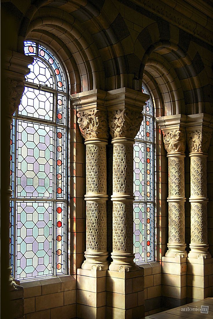 an old building with stained glass windows and columns in the center, along with a bench