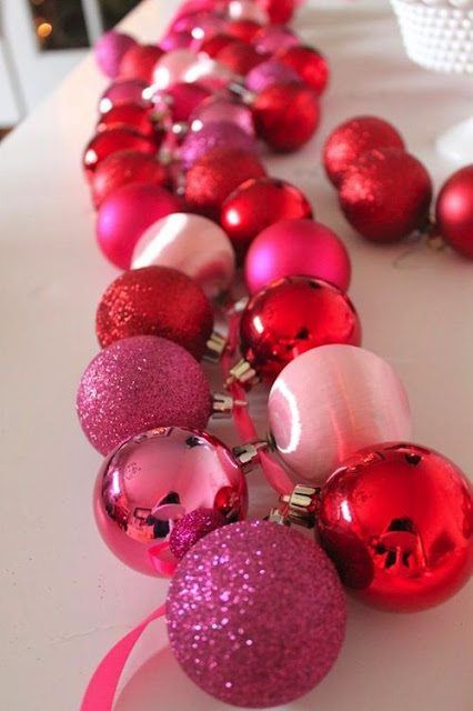 pink and red ornaments are lined up on a table