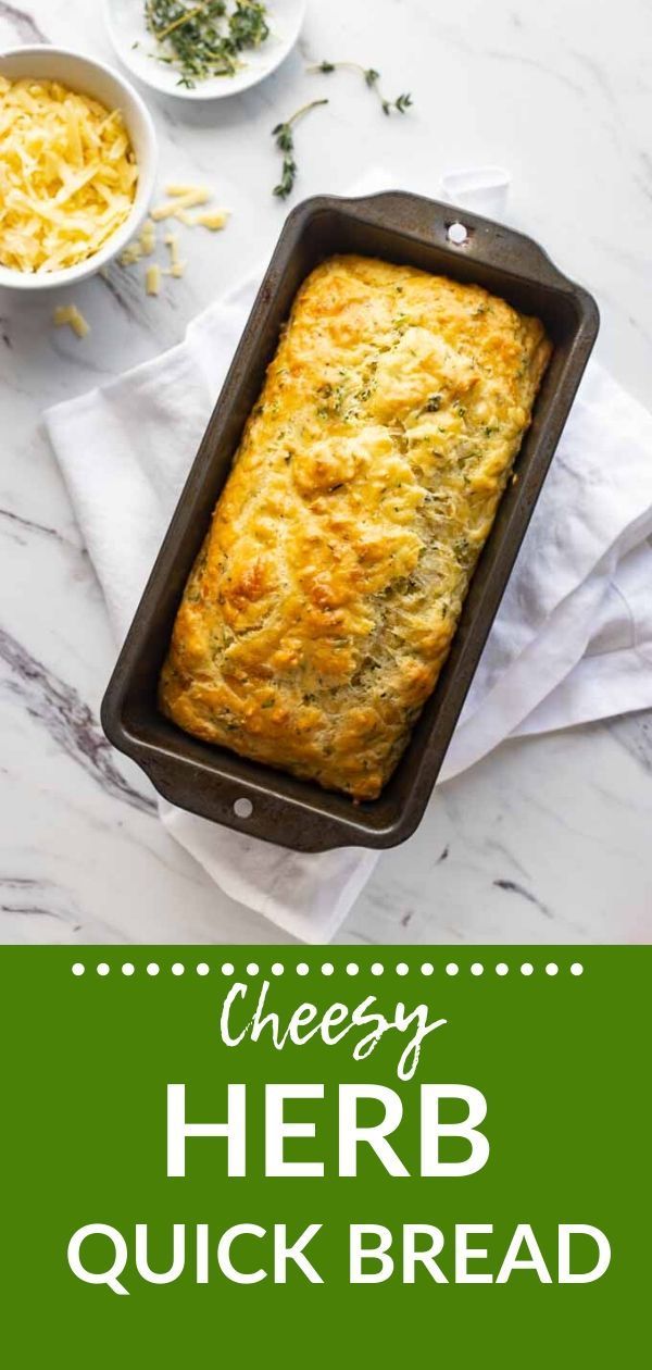 cheesy herb quick bread in a baking pan on a marble counter top with text overlay