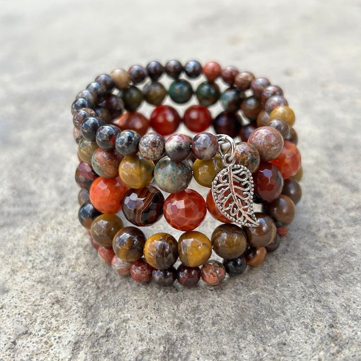 Earth tones of green, brown, red and orange define this 5 wrap boho bracelet.Genuine semi-precious stones featuring Tiger's Eye, Jasper, and Crackle Agate make up this done-for-you stack. 4mm round jasper 8mm Tiger's Eye 10mm faceted Crackle Agate one size fits most - best for small to medium wrists Handmade in Lincoln, Nebraska Earthy Hand-strung Brown Wrap Bracelet, Earthy Brown Hand-strung Wrap Bracelet, Earthy Hand-strung Wrap Bracelet With Round Beads, Multicolor Wrap Bracelet With Round Beads And Natural Stones, Brown Gemstone Beads Wrap Bracelet Gift, Bohemian Gemstone Beads Bracelets For Layering, Brown Natural Stone Wrap Bracelet Gift, Brown Hand-strung Wrap Bracelet With Round Beads, Earthy Brown Wrap Bracelet With Round Beads