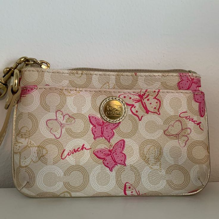 Beige, Cream And Gold Small Coach Wristlet With Butterfly Pattern. Gold Leather Strap, Pink Satin Fabric In The Inside, Zipper Closure. (6 X 4 X .75 Inches) Like New Condition, Never Used Butterfly Coach Bag, Pink Clutch Wristlet With Zipper Closure, Pink Pouch Wristlet With Zipper Closure, Pink Wristlet With Removable Pouch, Pink Wristlet With Removable Pouch As Gift, Pink Wristlet For Everyday Use In Spring, Pink Wristlet With Zipper Pouch As Gift, Pink Clutch Wristlet As A Gift, Chic Pink Wristlet For Everyday Use