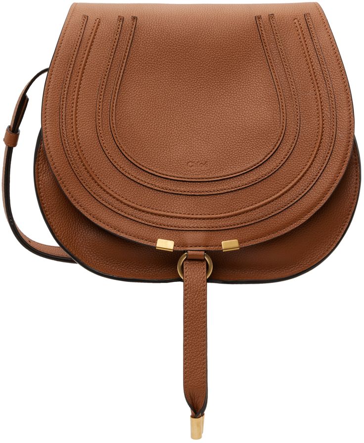 Grained calfskin saddle bag in tan. Burnished edges throughout. · Adjustable pin-buckle shoulder strap · Logo embossed at face · Concealed patch pocket at face · Foldover flap with tab-slot closure · Card slot at interior · Linen twill lining · H10 x W11.5 x D4.5 in Supplier color: Tan Brown Flap Saddle Bag With Gold-tone Hardware, Brown Saddle Bag With Gold-tone Hardware, Brown Saddle Bag With Detachable Strap, Brown Saddle Bag For Office, Saddle Bag With Detachable Strap, Cognac Saddle Bag For Office, Brown Calf Leather Saddle Bag For Everyday Use, Luxury Saddle Bag With Adjustable Strap, Cognac Saddle Bag With Adjustable Strap For Work