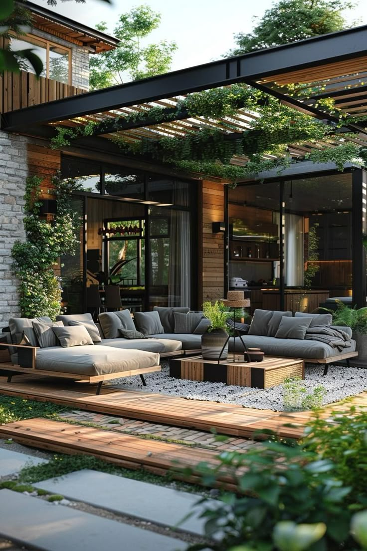 an outdoor living area with couches, tables and plants on the side of it