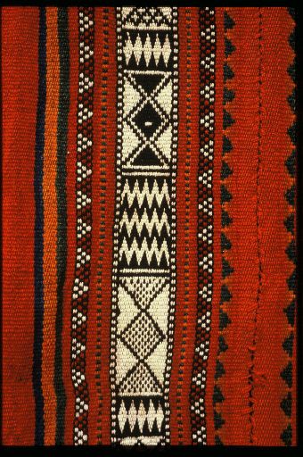 an orange, black and white striped cloth with different designs on it's sides