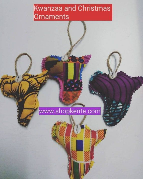 four african ornaments hanging from strings on a white background with the words kwanza and christmas ornaments