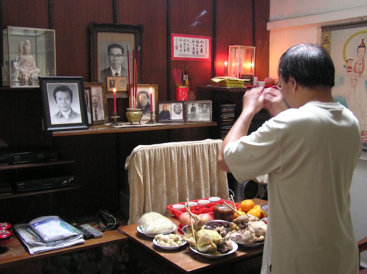 a man standing in front of a table filled with food and pictures on the wall