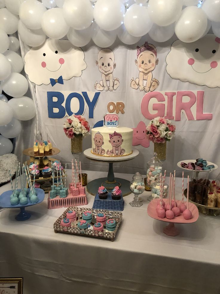 a table topped with lots of desserts and balloons in the shape of baby's first birthday cakes