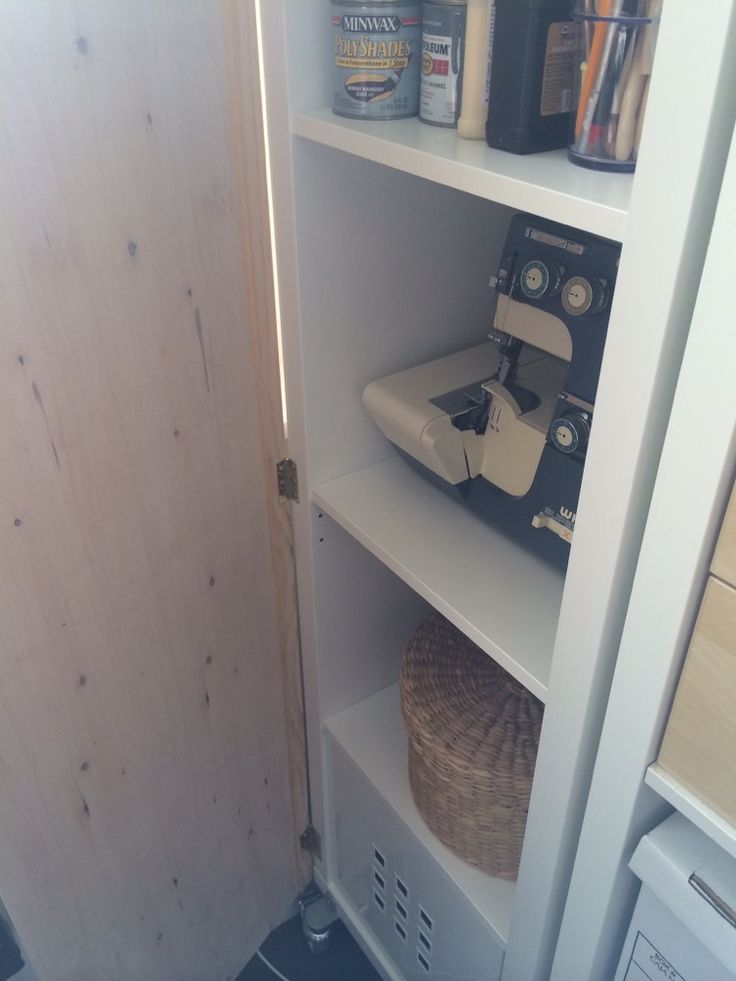 an open pantry door with some items on top and in the bottom shelf next to it