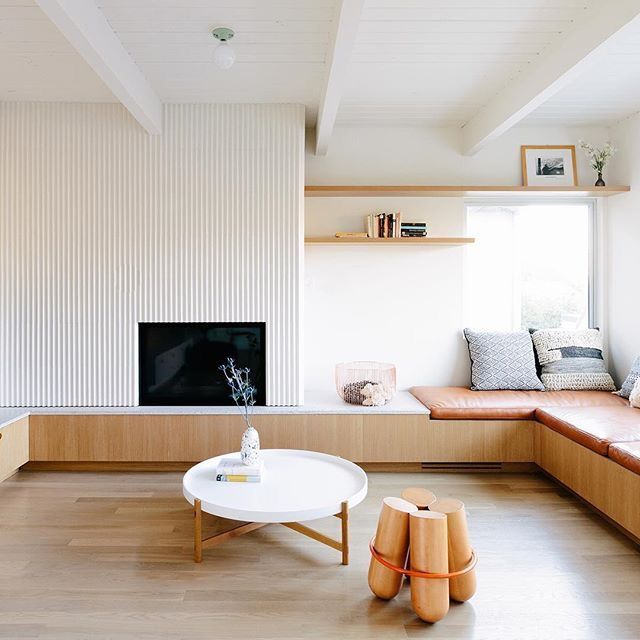 a living room filled with furniture and a flat screen tv mounted on a wall next to a window