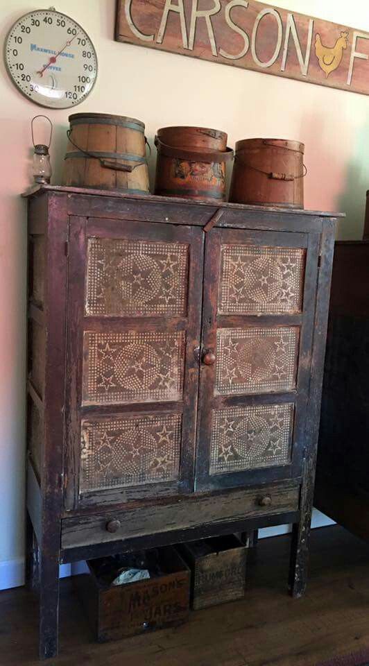 an old wooden cabinet with baskets on top