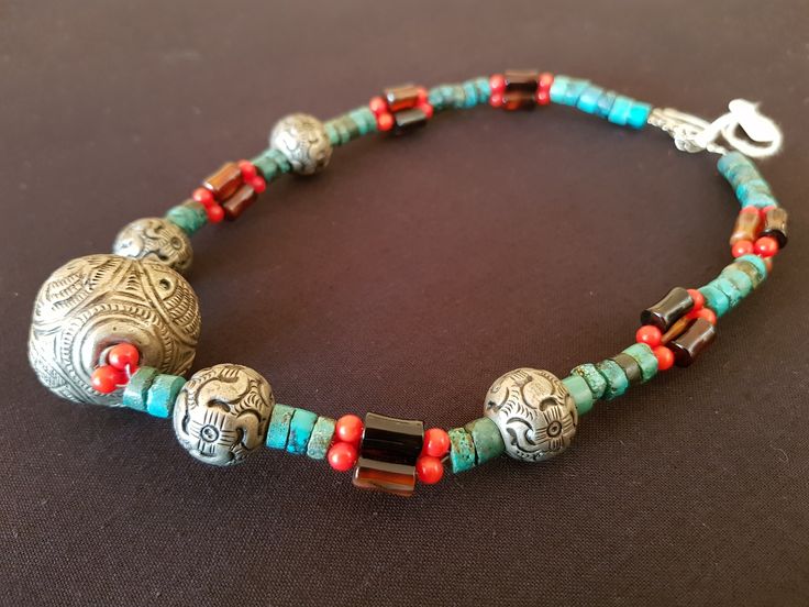 Beautiful handcrafted Tibetan tribal necklace from Lijiang, China. Large Tibetan silver central feature bead with traditional animal motifs. Single strand turquoise barrels and smaller Tibetan silver beads with triple strands of small  coral and larger amber barrels between. A stunning and colourful piece featuring old world stones. Length: 455mm (17.91") Weight: 61g (2.15oz) Traditional Turquoise Necklace For Festivals With Silver Accents, Traditional Silver Turquoise Necklace For Festivals, Silver Beaded Turquoise Necklace For Festivals, Traditional Turquoise Necklace With Round Beads For Festival, Handmade Silver Amulet Beads, Traditional Silver Beaded Necklace, Traditional Adjustable Turquoise Necklace, Adjustable Traditional Turquoise Necklace With Large Beads, Traditional Beaded Silver Turquoise Necklace