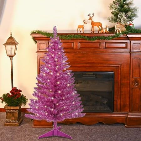 a purple christmas tree in front of a fireplace