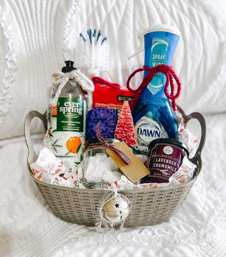 a basket filled with lots of different items on top of a white bed covered in blankets