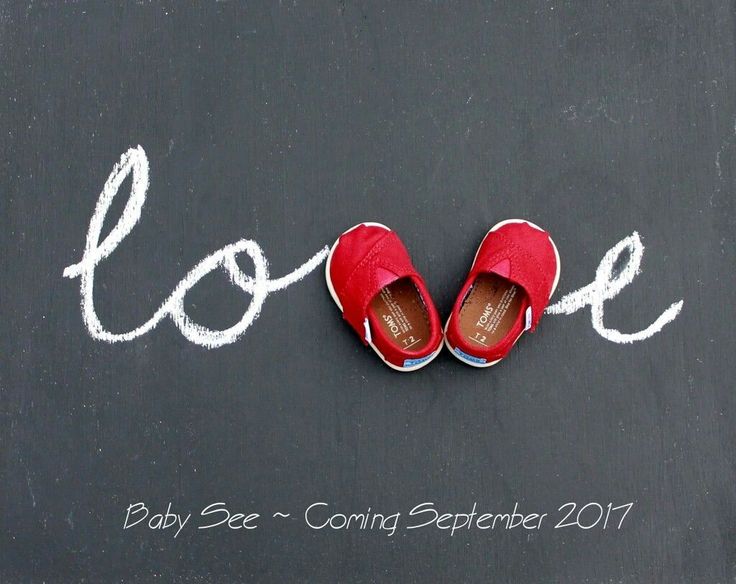 a pair of red shoes sitting on top of a chalkboard with the word love written in it