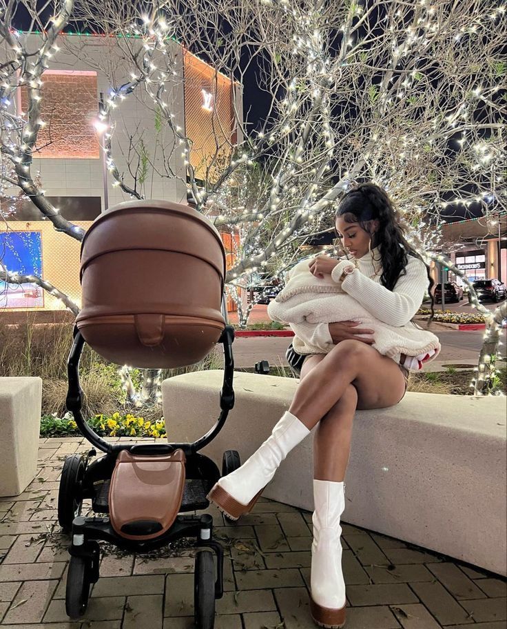 a woman sitting on a bench holding a baby carriage