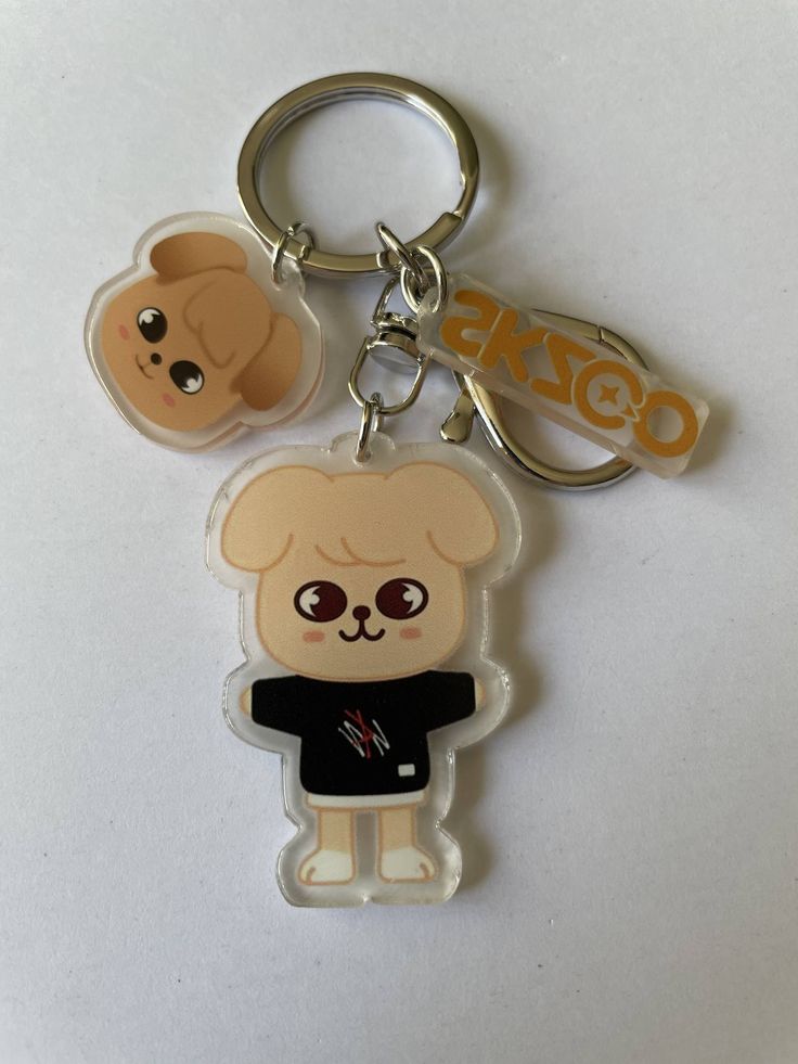 two key chains with an image of a teddy bear and a dog on one side