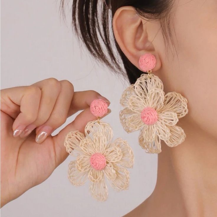 a close up of a person wearing some kind of earring with flowers on it