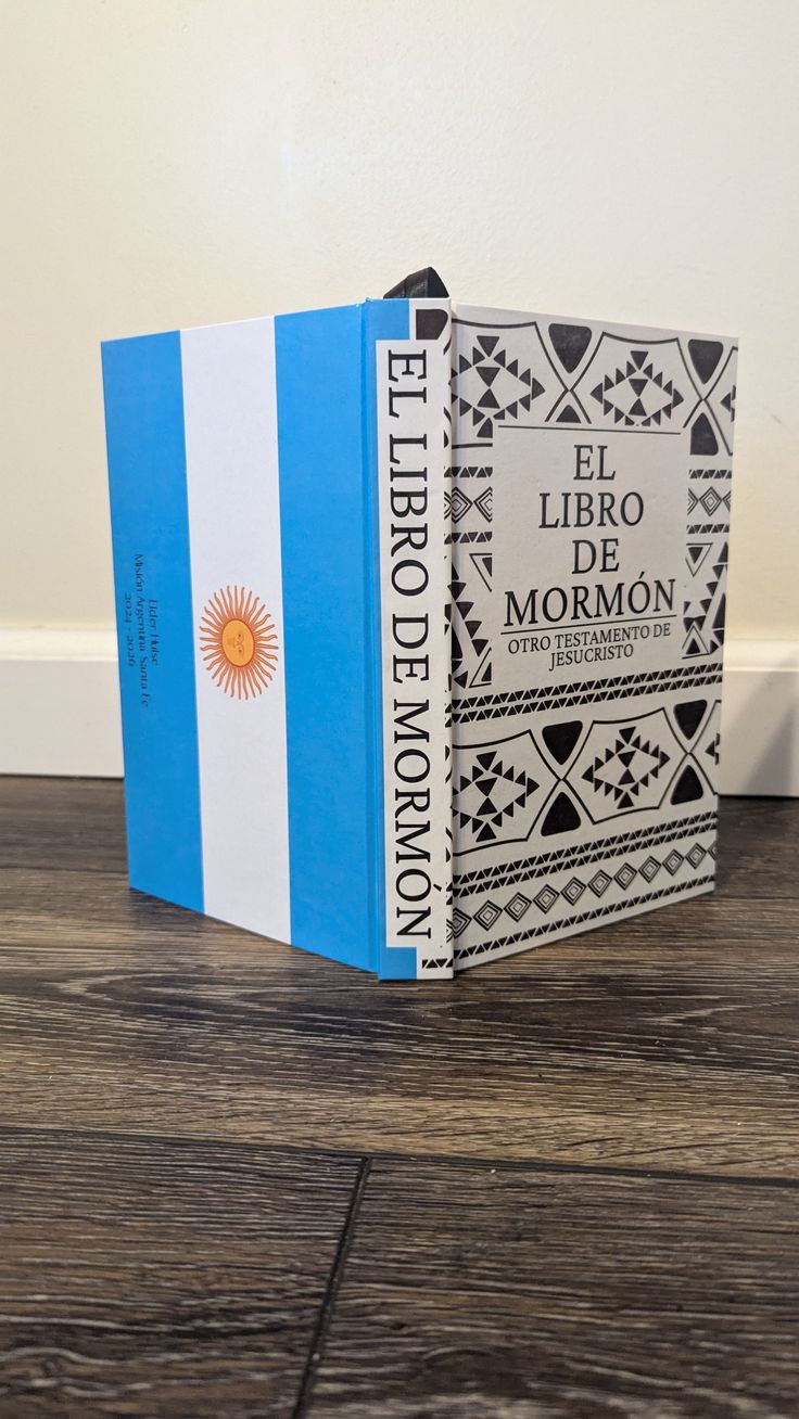 a blue and white book sitting on top of a wooden floor next to a wall