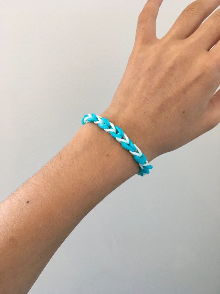 a person's hand wearing a blue bracelet with braiding on the outside of it