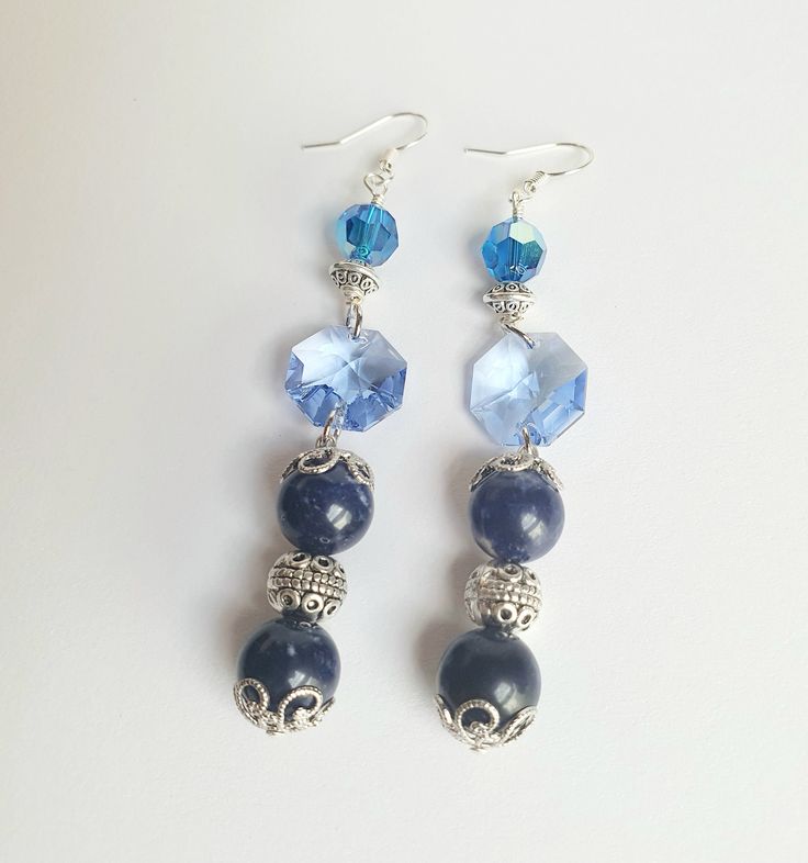 Benefit from the calming color of blue. You're looking at a lovely pair of handmade ear rings comprising two 10 mm sodalite beads on each piece, decorated with intricate silver bead caps.  Each piece is further accented with one blue hexagonal Swarovski crystal and a sapphire blue crystal, along with intricate spacers. Definitely a statement piece! Flaunt this pair at a party or to dinner.  This beauty is 7 cm long, from the base of the ear wire.  Healing properties: Sodalite promotes self expression and communication, giving the wearer a renewed sense of self-esteem. Thank you for looking at this listing at Crystal Bijoux by Emmie. You can explore all our handmade, one-of-a-kind, crystal jewelry collection here:  https://www.etsy.com/shop/crystalbijouxbyemmie We also custom make crystal j Crystal Dangle Earrings As Gift, Crystal Dangle Earrings For Gift, Elegant Dangle Earrings With Faceted Beads, Elegant Handmade Sterling Silver Beaded Earrings, Crystal Long Drop Earrings As Gift, Blue Beaded Sterling Silver Earrings, Adjustable Crystal Drop Earrings, Elegant Faceted Beads For Jewelry Making, Round Faceted Beads Earrings As Gift