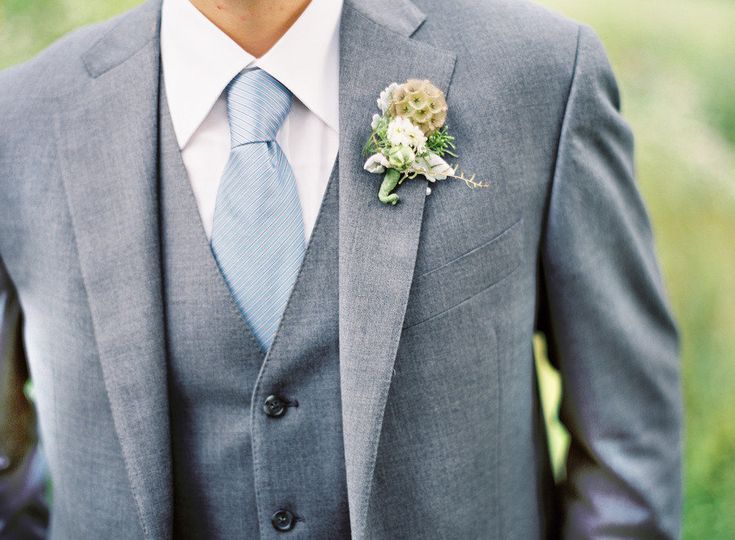 a man in a suit and tie with a boutonniere on his lapel