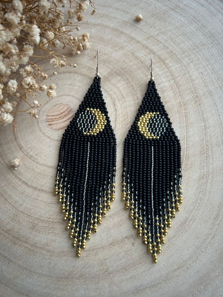 These long earrings made of black beads with fringe and a golden moon motif represent a unique combination of style and mysterious allure. The black color adds elegance to the piece, while the golden moon creates a mysterious and noble accent. Made from Czech beads. Length 4.8 inches(12cm). Width 1.2 inches(3cm). Hypoallergenic clasp. If you want these earrings in a different color, write to me and I will be happy to make them for you. Bohemian Black Teardrop Beaded Earrings, Bohemian Black Tassel Earrings With Round Beads, Black Bohemian Tassel Earrings With Round Beads, Handmade Black Moon Earrings, Handmade Black Moon-shaped Earrings, Black Tassel Earrings With Dangling Beads As Gift, Bohemian Black Tassel Earrings As Gift, Black Beaded Tassel Earrings With Round Beads, Handmade Black Crescent Earrings