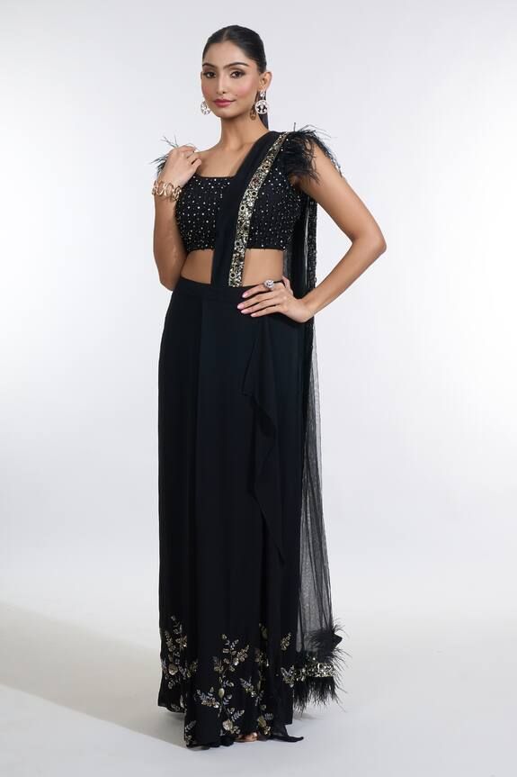 Black pre-draped skirt saree with confetti sequin embroidered palla border. Paired with a ostrich feather embellished short sleeves bead embellished blouse and a sequin embellished belt. - Aza Fashions Embellished Black Pre-draped Saree For Party, Glamorous Black Pre-draped Saree, Hand Embellished Sharara For Evening Party Wear, Black Pre-draped Saree With Sequins, Embellished Georgette Sharara For Evening, Traditional Hand Embellished Pre-draped Saree For Evening, Glamorous Evening Sharara In Georgette, Glamorous Evening Lehenga With Traditional Drape, Elegant Floor-length Evening Choli