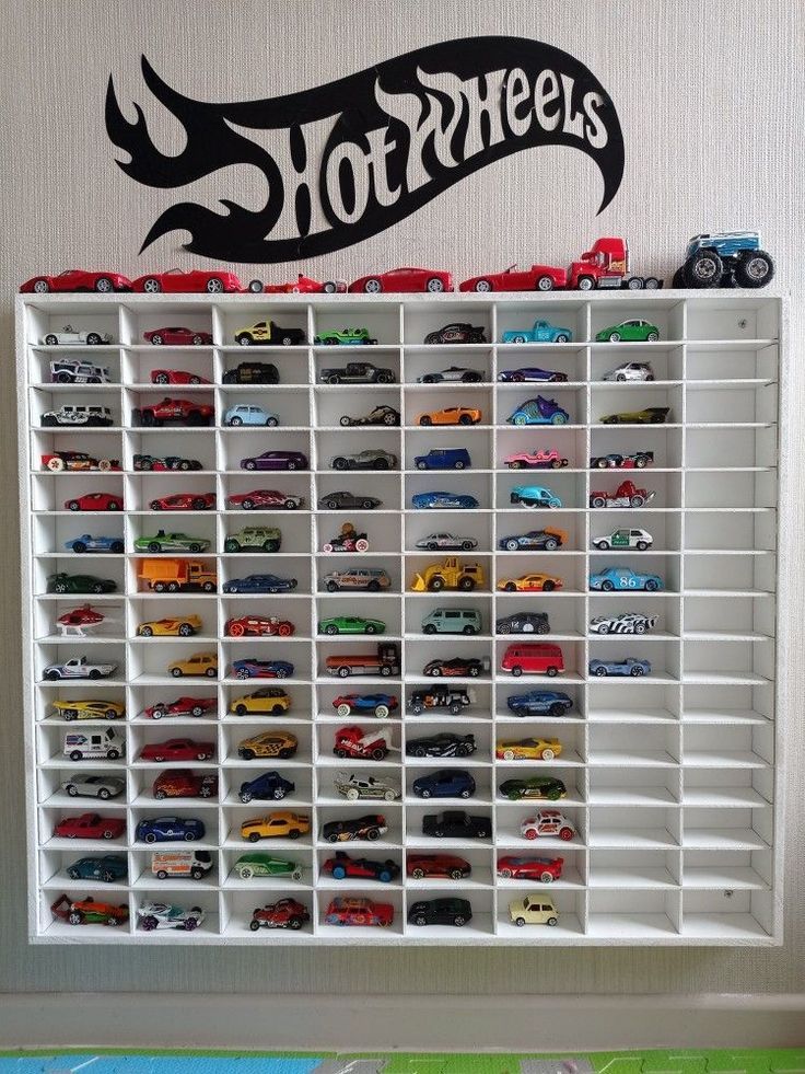 a toy car display in front of a hot wheels wall decal on the wall