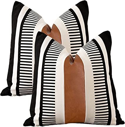 two black and white striped pillows with brown trims on each pillow, one in the shape of a heart