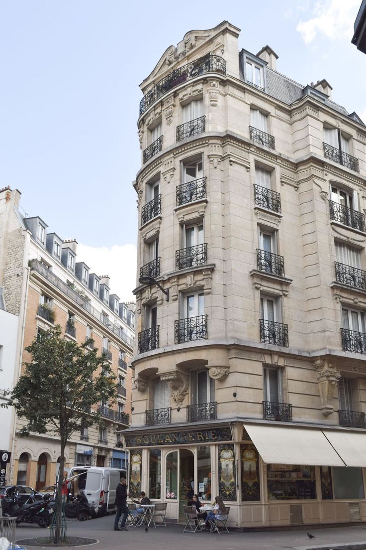 an apartment building with balconies and bicycles parked on the street in front of it