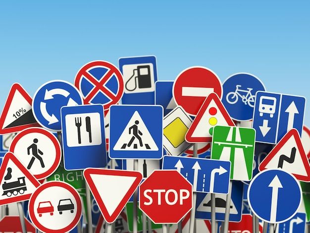 many different street signs are stacked on top of each other in front of a blue sky