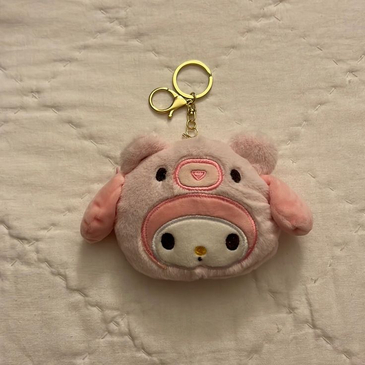 a small stuffed animal keychain on a bed