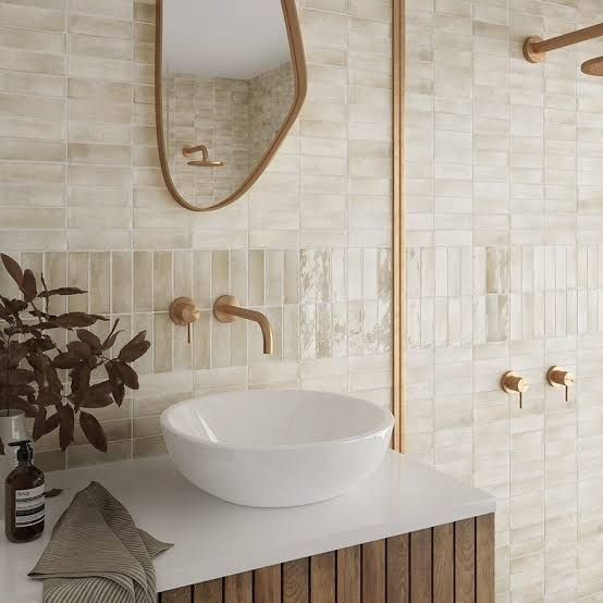 a white sink sitting on top of a counter next to a mirror and wooden faucet