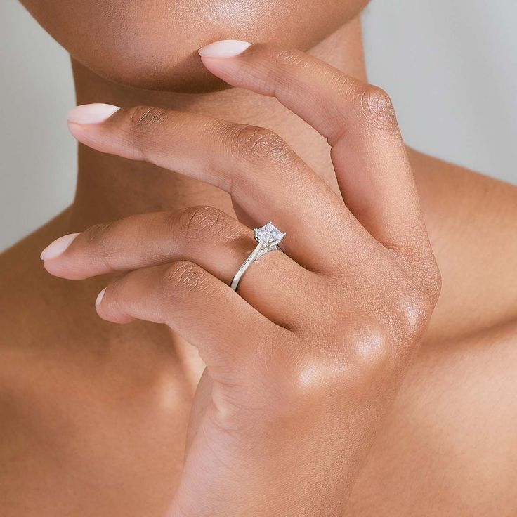 a woman wearing a diamond ring on her finger