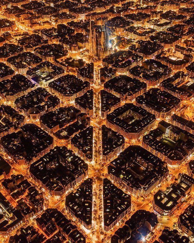 an aerial view of a city at night with lights in the streets and tall buildings