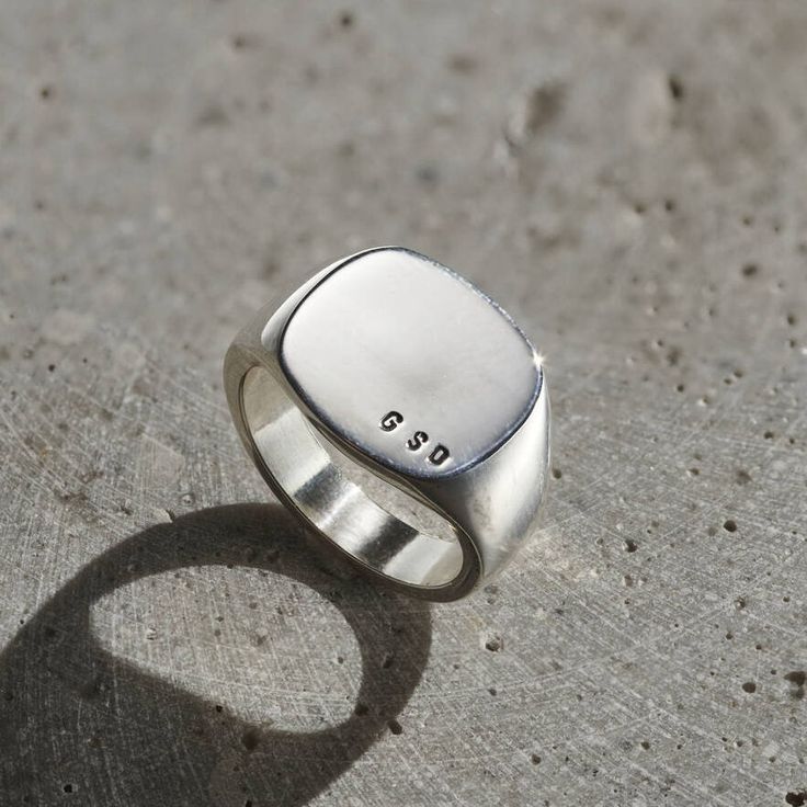 Our Personalised Men's Sterling Silver Rounded Square Signet ring is a chunky contemporary twist on a traditional signet ring design. This gorgeous personalised ring is made from 925 Sterling Silver. Larger than our usual signet rings this design is the perfect way to make a statement. Our jewellers can personalise your ring with your chosen initials, letters or numbers. Making this ring the perfect personalised gift for him. Choose from black or clear letter finish. Please specify your ring size (this is the standard UK letter ring size). Dimensions: The bezel of the signet ring measures 1.4cm x 1.4cm. Band width 1.4cm at widest point and 0.5cm at narrowest point. Made from: 925 sterling silver, polished finish. We can only stamp the Roman alphabet in the font shown in the product images. Signet Ring Design, Roman Alphabet, Signet Ring Silver, Russian Ring, Signet Ring Men, Rounded Square, Letter Ring, Jewelry Lockets, Silver Signet Ring