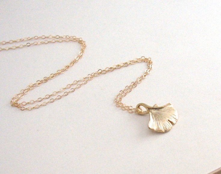 "A gorgeous gold ginkgo leaf hangs from a beautiful 14k Gold-Filled chain. The ginkgo shape and shade of gold are so pretty in this pendant. Leaf is textured on either side. - Pendant - Matte Gold plated brass - 14mm x 16mm - Chain + components - 14K Gold Fill - Clasp - 14K Gold-Filled lobster clasp . . . . . . . . . . . . . . . . . . . . . . . . . . . . . . . . . Want more for bridesmaids, sisters or friends? I am happy to put custom orders together! . . . . . . . . . . . . . . . . . . . . . . Delicate Petal-shaped Gold Jewelry, Gold Leaf-shaped Jewelry Gift, Delicate Gold Leaf-shaped Jewelry, Ginkgo Jewelry, Gingko Leaf Jewelry, Nature-inspired Gold Leaf Necklace, Leaf Necklace Gold, Ginkgo Leaf Necklace, Necklace Leaf