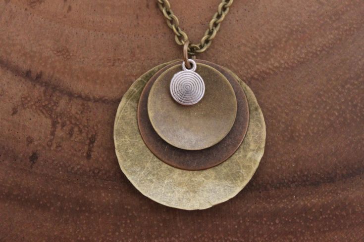 Boho Necklace Pendant Bohemian Necklace pendant Boho Jewelry Necklace Pendant Mixed Metal Pendant Necklace Brass Necklace Bohemian Jewelry Finish : Antiqued Brass ( 32mm ) copper disc round and silver plated swirl and antique brass chain. Matching Earrings : https://www.etsy.com/listing/493613967/boho-earrings-copper-earrings-dangle?ref=shop_home_active_9 Necklace section : https://www.etsy.com/shop/NtikArtJewelry?section_id=16089749 To return to my shop : https://www.etsy.com/shop/NtikArtJewelr Bohemian Metal Charm Necklace With Lobster Clasp, Bohemian Necklace With Unique Round Pendant, Bohemian Brown Metal Necklace, Handmade Bohemian Charm Necklaces, Handmade Bohemian Round Charm Necklaces, Handmade Bohemian Charm Necklace, Bohemian Handmade Round Charm Necklaces, Hippie Metal Necklace For Gift, Hippie Metal Necklace For Gifts