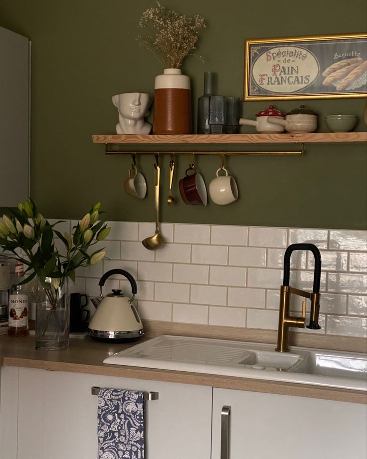 Kitchen corner with Olive green walls and countryside vintage inspired decoration Green Kitchen Ideas Paint Colours, Kitchen Ideas Dark Walls, Olive Green Outside House Paint, Cozy Green Kitchen Aesthetic, Olive Green Kitchen Tiles, Farrow And Ball Olive 13, Olive And Grey Kitchen, Olive Walls Kitchen, Olive Green And White Kitchen