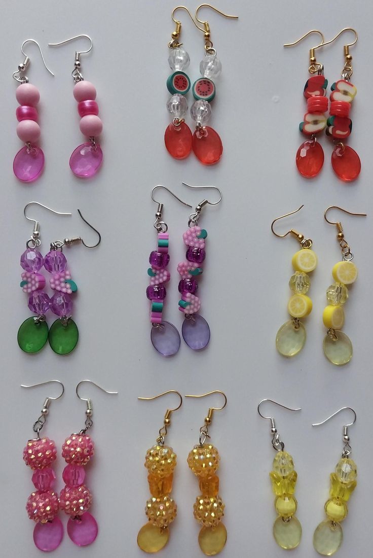 many pairs of earrings are displayed on a white surface