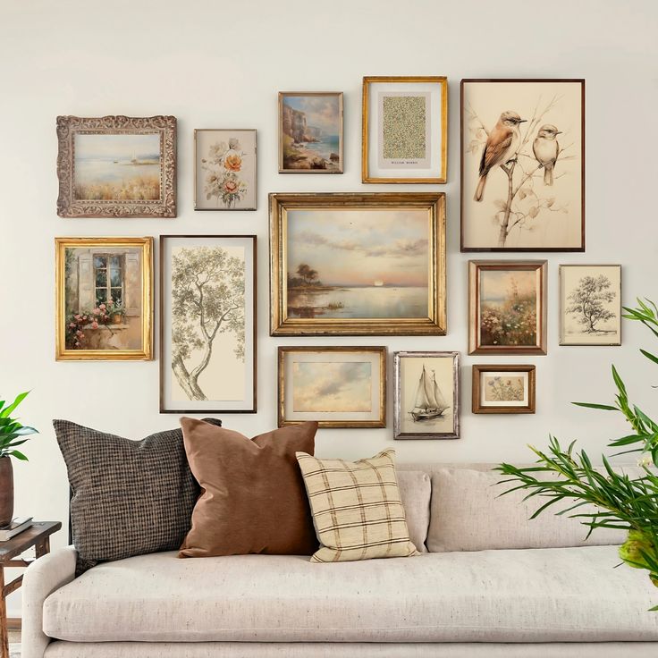 a living room filled with lots of framed pictures on the wall above a white couch