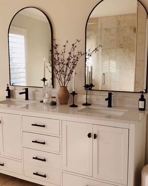 a bathroom with double sinks and mirrors on the wall