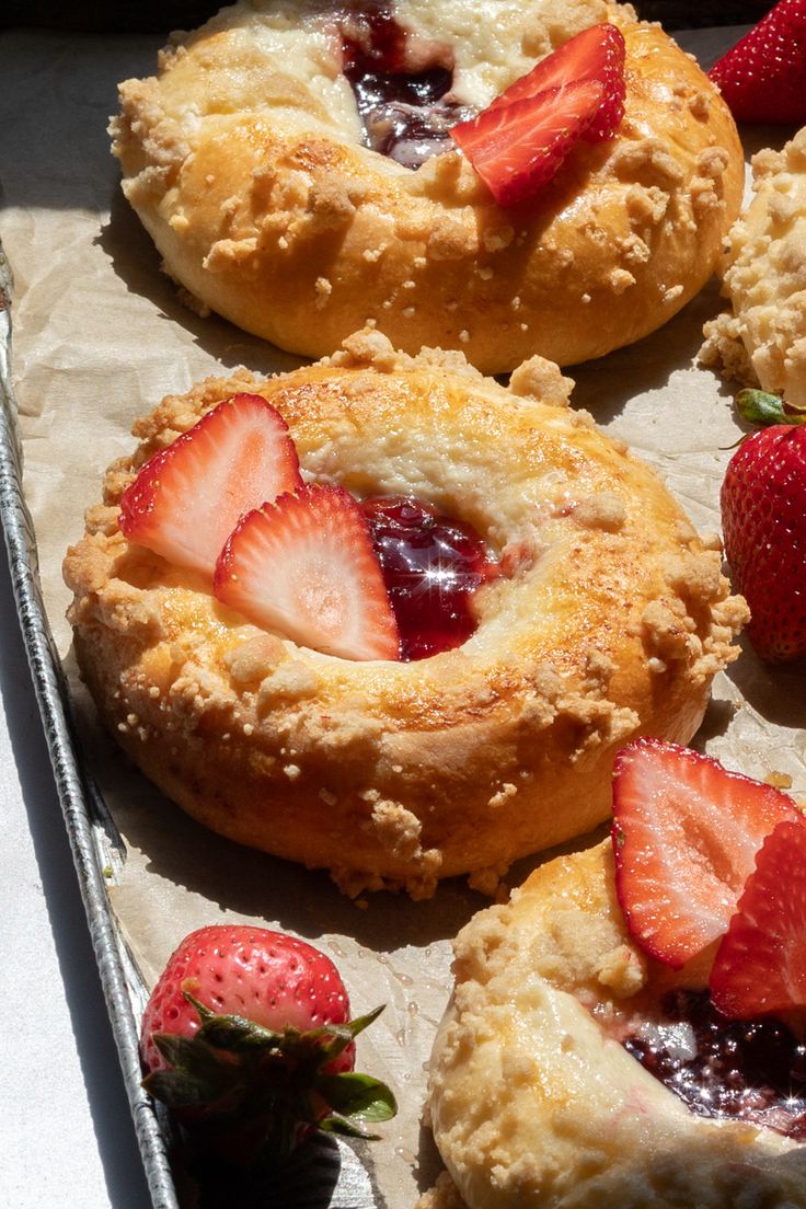 strawberry shortcakes with jam and strawberries on top are sitting on a baking sheet