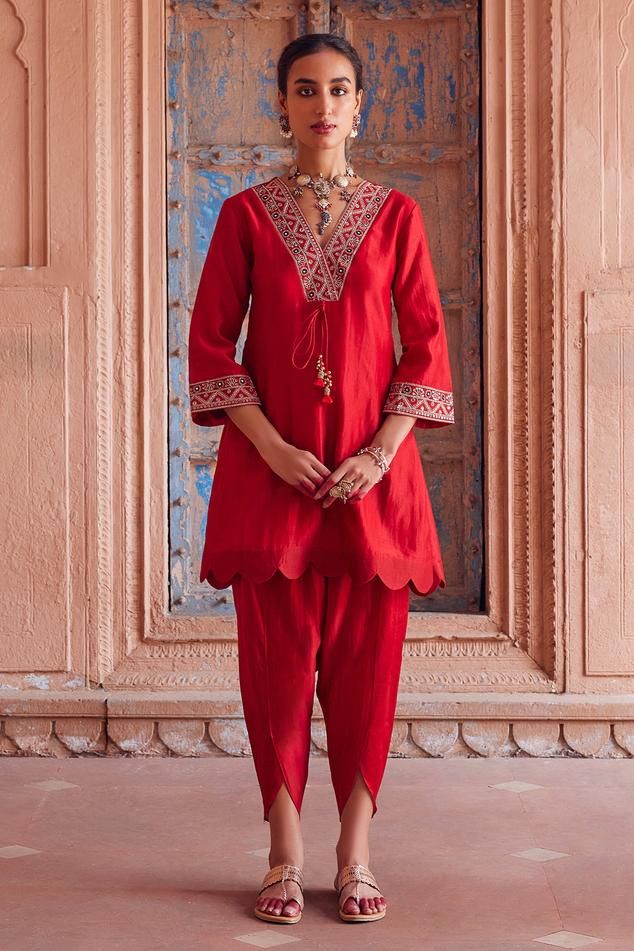 Red three fourth flared sleeves kurta with floral embroidered neckline, cuffs and ghungroo embellishments tassels front tie-up. Paired with matching tulip pant.
Components: 2
Pattern: Embroidery
Type Of Work: Floral 
Neckline: V Neck
Sleeve Type: Three Fourth
Fabric: Chanderi Silk, Cotton Mul
Color: Red
Other Details: 
Ghungroo tassels on yoke
Scallop hem kurta
Length:
Kurta: 35 inches
Tulip pant: 36.5 inches
Note: The jewellery worn by the model is not for sale
Note: Kindly contact customer ser Short Kurti With Tulip Pants, Suit With Tulip Pants, Tulips Pants, Kurta Pant Set, Tulip Pants Suit, Kurta With Tulip Pants, Three Fourth Sleeve Blouse Designs, Mul Cotton Dresses, Tulip Pants Outfit