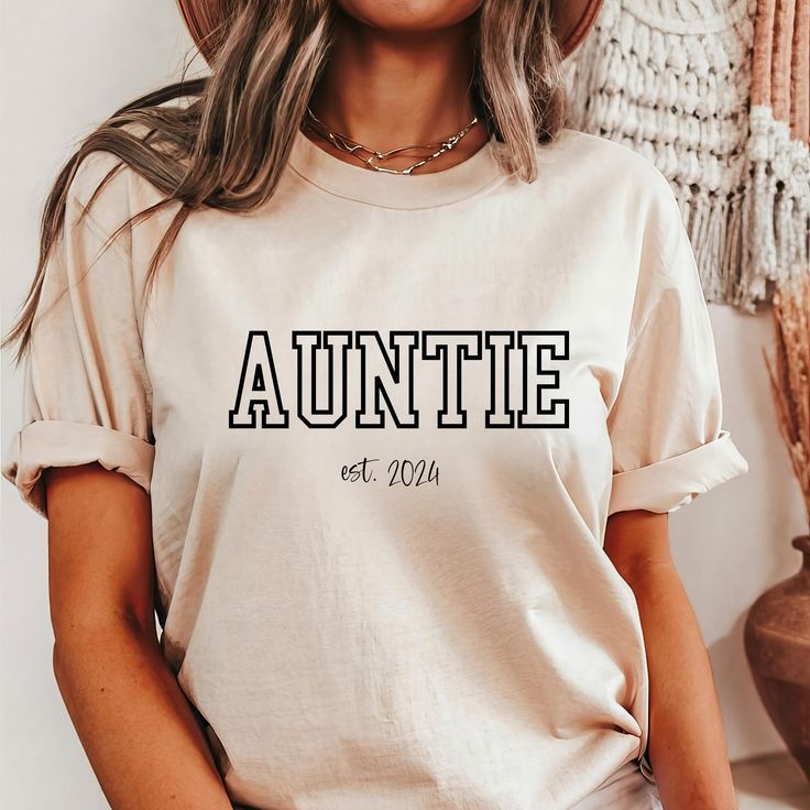 This Auntie Shirt is the perfect gift! ❤️ This Auntie T-shirt is made with the highest quality materials and is comfortable and cute! This Personalized Shirt would make a great gift for a new aunt or for an aunt that you want to show some love to!  How to Order: Select shirt size, select shirt color, and type year personalization request in box.  Font is black on all shirts, except white font on the black shirts. Sizing: Unisex fit. Please see size chart in the listing. You might also measure your favorite tee and compare to the size chart to find the best fit for you. Sleeves may be rolled up in some photos- they will not come rolled up upon arrival. Material: -BellaCanvas 3001 Unisex Tee -100% Airlume combed and ring-spun cotton, a lightweight fabric (4.2 oz/yd² (142 g/m  -Unisex fit -Te Auntie Tee Shirts, Pre-shrunk Crew Neck Shirt As Gift, Casual Crew Neck Shirt Perfect For Gifts, Casual Letter Print Tops As Gift, Custom Print Relaxed Fit Shirt As Gift, Short Sleeve Shirt With Name Print For Gift, Relaxed Fit Tops With Custom Text For Gifts, Relaxed Fit Tops With Custom Text As Gift, Short Sleeve Shirt With Letter Print For Gift