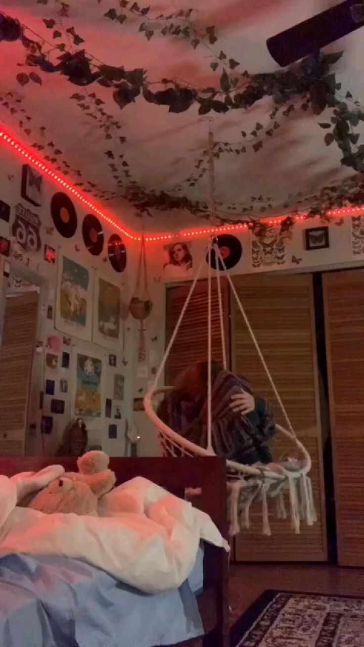 a bedroom decorated in pink and white with lots of decorations on the ceiling, including a hammock