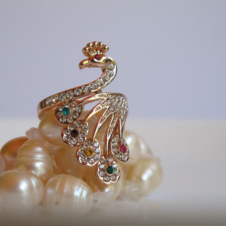 You'll be pretty as a Peacock with this costume ring on your finger and just as proud, too, for its rhinestones are sure to dazzle and delight and its elongated shape will lend an aura of elegance. The Bird measures just over 1.25 inches in length and is 7/8 inch wide from rhinestone to rhinestone. You'll find the ring to be in excellent, like new condition and ready to impress at your next soiree. Peacock Ring Design Gold, Peacock Jewellery Design, Pacchala Haram, Peacock Jewellery, Bird Peacock, Peacock Gifts, Peacock Ring, Peacock Jewelry, Ring Jewellery Design